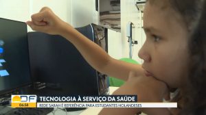 Captura de tela do Bom Dia DF, da TV Globo, mostra garoto exercitando o braço direito com jogo de computador no laboratório de realidade virtual do SARAH Brasília Lago Norte.