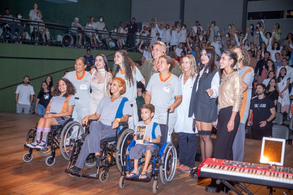 Orlando Morais, suas filhas e Cleo Pires posando para foto junto à Dra. Lúcia Willadino Braga e o público do Teatro SARAH