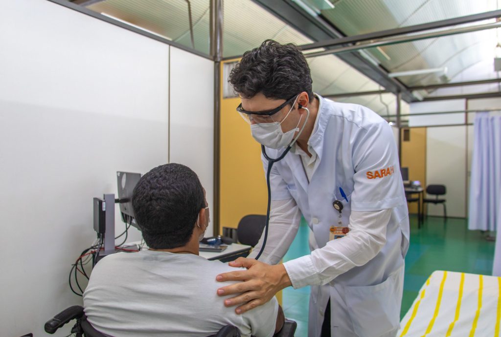 Médico do SARAH auscultando um paciente